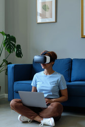 Взрослая женщина, использующая vr-гарнитуру и ноутбук для дистанционного обучения - AnnaStills