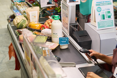 Женщина просматривает продукты на конвейере в супермаркете - Pressmaster