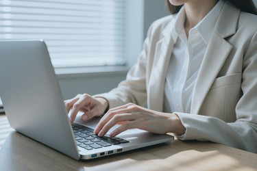Взрослая женщина печатает на ноутбуке для удаленной работы. - Pressmaster