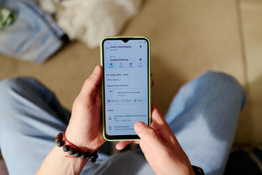 Мужчина, планирующий отпуск на смартфоне для летнего путешествия - DragonImagesAsia