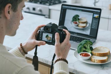 Взрослый мужчина фотографирует еду для онлайн-маркетингового контента - Mediaphotos