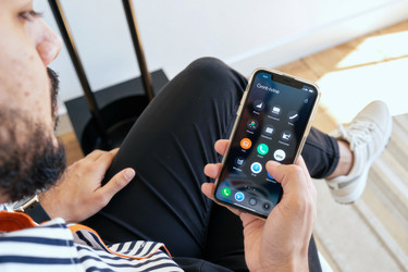 Взрослый мужчина, использующий смартфон для навигации по мобильному приложению дома - DragonImagesAsia
