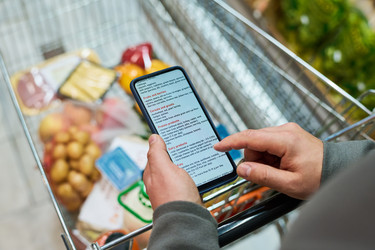 Взрослый мужчина, пользующийся смартфоном в супермаркете крупным планом - Pressmaster
