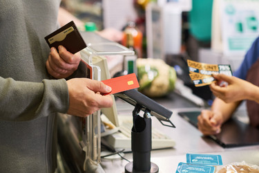 Покупатель оплачивает продукты на кассе супермаркета - Pressmaster