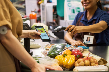 Adult Woman with Diabetes Paying for Healthy Groceries by Smartphone - Pressmaster