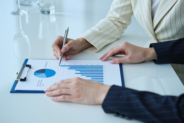 Деловые женщины рассматривают отчет о продажах для совещания по корпоративной стратегии - Pressmaster
