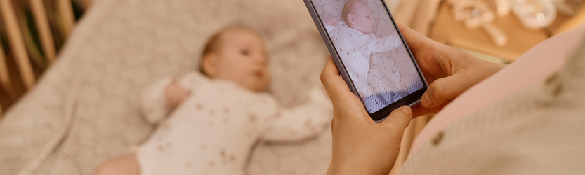 Взрослая мать фотографирует ребенка дома для родительского контента - SeventyFour