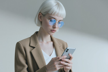 Взрослая женщина, использующая смартфон для кампании мобильной связи - Mediaphotos