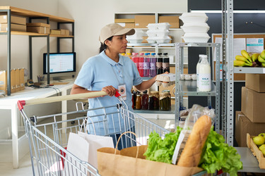 Женщина, готовящая заказы на продукты в пункте самовывоза продуктов питания - Pressmaster