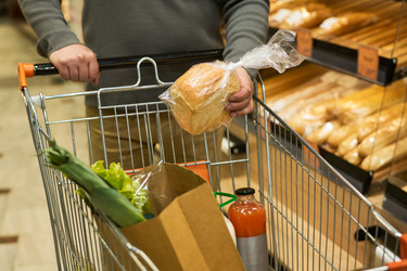 Взрослый покупатель выбирает хлеб в продуктовом отделе супермаркета - Pressmaster