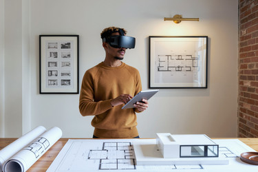 Чернокожий мужчина, использующий vr-гарнитуру и планшет для архитектурного проектирования - Mediaphotos