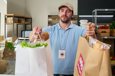 Мужчина готовит заказы на самовывоз продуктов для службы доставки еды - Pressmaster