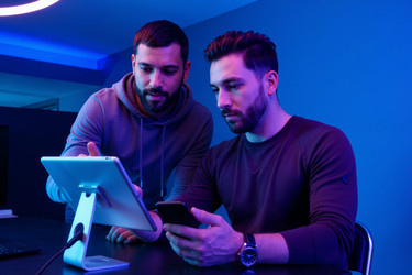 Взрослые мужчины рассматривают планшеты и смартфоны для цифрового документооборота - Mediaphotos