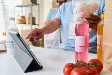 Мужчины обрабатывают заказы в пункте приема продуктов питания для доставки - Pressmaster