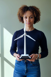 Портрет чернокожей женщины, держащей в руках модель ветряной турбины для получения чистой энергии - DragonImagesAsia
