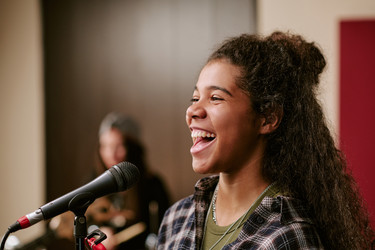 Двухрасовая девочка-подросток поет во время репетиции группы для продвижения музыки - AnnaStills