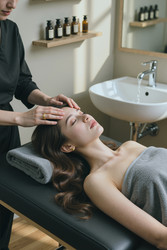 Взрослая женщина, получающая массаж лица в спа-клинике wellness - DragonImagesAsia