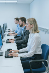 Бизнес-профессионалы печатают на настольных компьютерах в офисе - Pressmaster