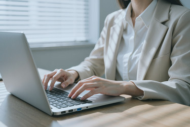 Взрослая женщина печатает на ноутбуке для удаленной работы. - Pressmaster