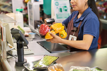 Испаноязычная женщина, обрабатывающая свежие продукты на кассе супермаркета - Pressmaster