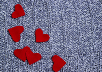 Текстильный фон. Красные сердечки на мягком вязаном одеяле. Концепция Дня святого Валентина - Alex0