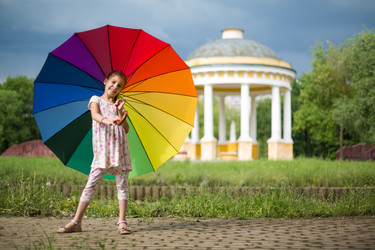 Девочка с разноцветным зонтиком на природе у красивой беседки - paha_l