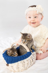 Улыбающаяся малышка в белом меховом одеянии с двумя маленькими котятами в корзинке - paha_l