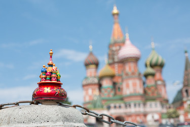 Игрушечный миниатюрный собор стоит на бетонном основании на фоне собора Василия Блаженного - paha_l
