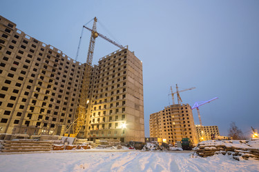 Вечером ведется строительство больших многоквартирных домов с помощью крана и грузовика - paha_l