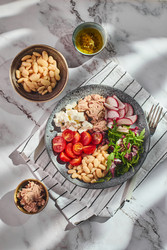 Полезный салат из тунца в миске с белой фасолью, сыром фета, помидорами, редисом и зеленью на мраморном столе - Irrin0215