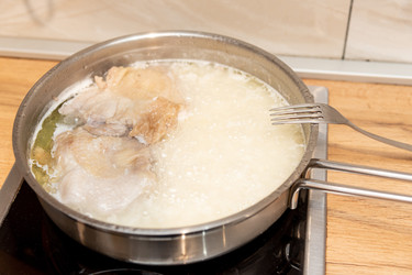 Обед и ужин: рис и куриное мясо, приготовленные в металлической сковороде из нержавеющей стали на домашней кухне - Matroskin
