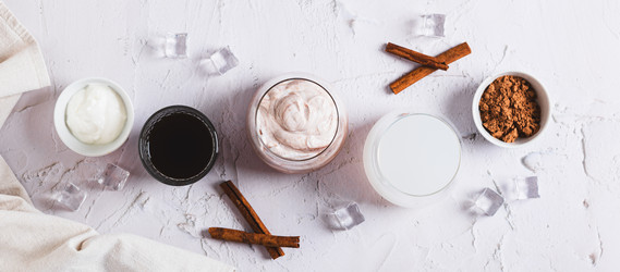 Вкусный модный протеиновый кофе с йогуртом в стакане, вид сверху, веб-баннер - Elena Rui