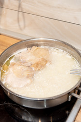 Обед и ужин: рис и куриное мясо, приготовленные в металлической сковороде из нержавеющей стали на домашней кухне - Matroskin