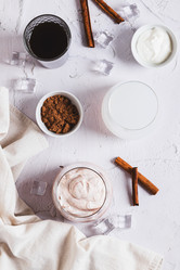 Вкусный модный протеиновый кофе с йогуртом в стакане на столешнице, вид сверху - Elena Rui