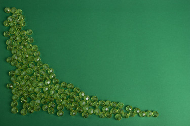 Зеленые пластиковые бусины на зеленом фоне - Alex0