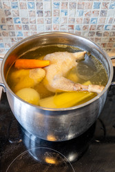 В кастрюле варится куриный суп с овощами - vale