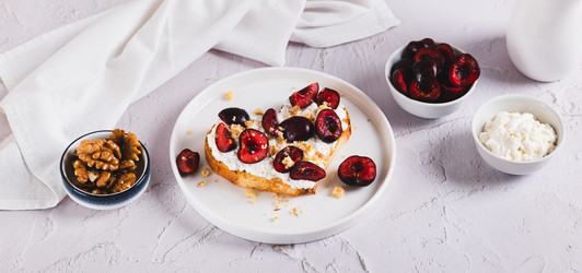 Вкусные бутерброды с рикоттой, вишней и орехами на тарелке на столе (веб-баннер) - Elena Rui