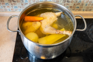 В кастрюле варится куриный бульон с овощами - vale