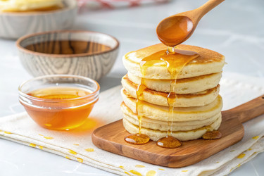 Вкусные блинчики, политые медом с помощью деревянной ложки. Генеративный ИИ - RomanZ