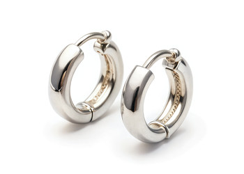 Серьги-кольца Huggie Hoop, сверкающие серебром на белом фоне. Генеративный ИИ - RomanZ