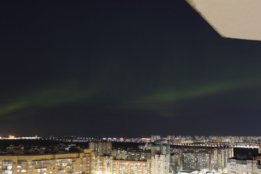 Зеленое полярное сияние (Aurora Borealis) над спящим ночным городом с видом из окна - Staisy