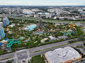 7 июля 2026 года. Полет дрона над аквапарком Volcano Bay с видом на вулкан, бассейны, горки и проезжую часть автомагистрали в Орландо, Флорида, США - EOS_Canon
