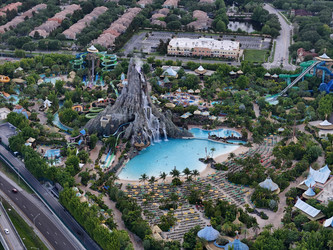 7 июля 2026 года. Полет дрона над аквапарком Volcano Bay с видом на вулкан, бассейны, горки и проезжую часть автомагистрали в Орландо, Флорида, США - EOS_Canon