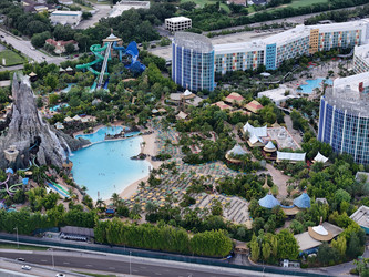 7 июля 2026 года. Полет дрона над аквапарком Volcano Bay с видом на вулкан, бассейны, горки и проезжую часть автомагистрали в Орландо, Флорида, США - EOS_Canon