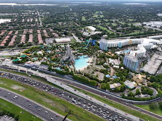 7 июля 2026 года. Полет дрона над аквапарком Volcano Bay с видом на вулкан, бассейны, горки и проезжую часть автомагистрали в Орландо, Флорида, США - EOS_Canon