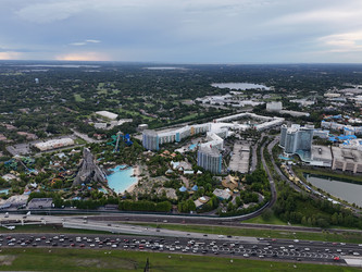 7 июля 2026 года. Полет дрона над аквапарком Volcano Bay с видом на вулкан, бассейны, горки и проезжую часть автомагистрали в Орландо, Флорида, США - EOS_Canon