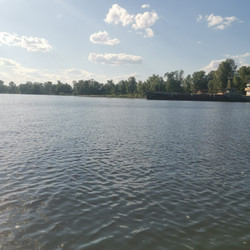 Широкая гладь реки с легкой рябью на воде и кучевыми облаками на небе в летний день - Anna_m