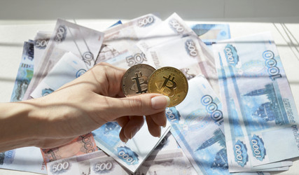 Две биткоин-монеты на фоне российских рублей. Концепция отказа от бумажных денег и перехода к безналичным платежам, виртуальной валюте, электронной коммерции и торговле - Dimasik_85