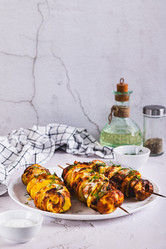 Мясо и картофель, запеченные на шампурах в аэрогриле, на тарелке на столе (вертикальный вид) - Elena Rui