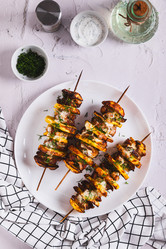 Сульваки, приготовленные из мяса и картофеля на шампурах, подаются на тарелке на столе, вид сверху - Elena Rui